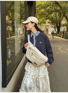 Photo de rue d'un grand sac de poitrine beige porté par une femme en tenue décontractée