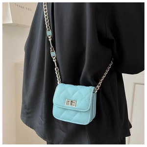 Detail of light blue quilted mini crossbody bag with silver clasp and chain on model
