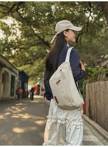 Vue détaillée du sac bandoulière en nylon crème avec zips et large bandoulière confort