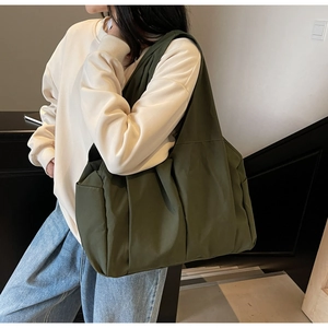 Détail du grand sac cabas vert foncé en nylon avec poches latérales et bandoulière