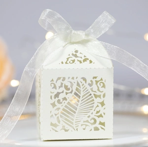 White laser-cut leaf gift box with pearl paper finish and silk ribbon for wedding candy