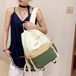 Lifestyle shot of a three-color nylon patchwork backpack worn by a model in casual setting