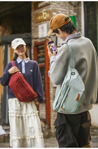 Détail de sacs à bandoulière bordeaux et vert menthe avec patch en cuir en milieu urbain
