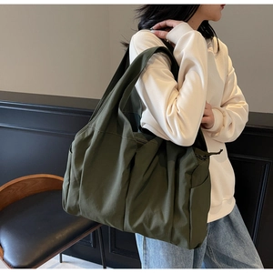 Détail du sac bandoulière vert armée en nylon avec texture plissée et zip métallique