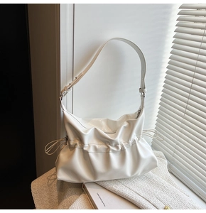 Détail du sac à bandoulière blanc plissé avec cordons et texture en cuir lisse