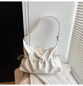 Détails d'un sac à bandoulière blanc plissé avec fini brillant et cordons latéraux