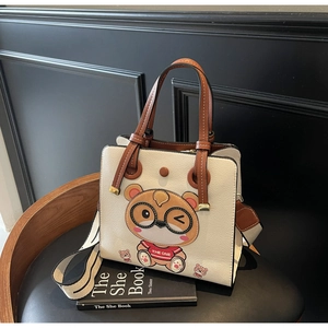 Close-up of beige tote bag with litchi grain texture and cartoon hamster character detail
