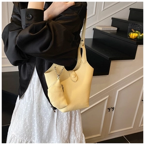 Close-up of a yellow lychee pattern leather bucket bag with matching small zipper pouch