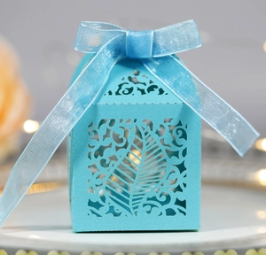 Close-up of laser-cut leaf pattern gift box in blue pearlescent paper with ribbon