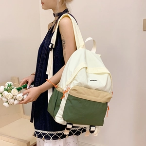 Detail view of water-resistant nylon backpack with contrast colors and drawstring side pockets