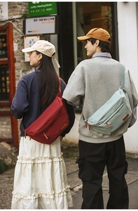 Sacs bandoulière en nylon rouge et vert portés par des modèles en extérieur