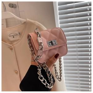 Detail of pink quilted crossbody bag showing silver chain strap and COCO charm decoration