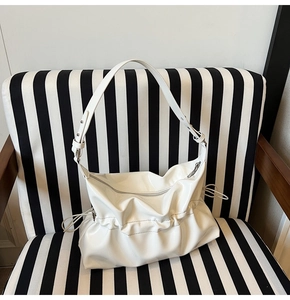 Vue détaillée du sac nuage plissé blanc en cuir verni brillant avec large bandoulière