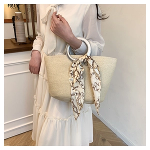 Fashionable straw tote bag with silver metal ring handles and elegant silk scarf detail