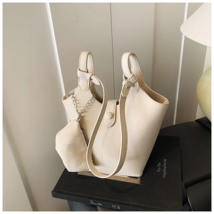 Close-up of creamy white lychee grain leather bucket bag with silver hardware and mini pouch