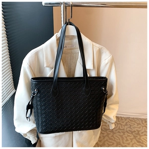 Detailed view of the black woven tote bag with Intrecciato pattern and silver ring buckle