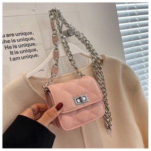 Detailed macro view of pink quilted leather crossbody bag with silver COCO letter chain