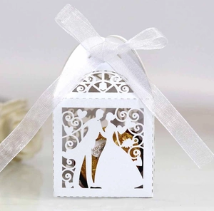 Detailed laser-cut white wedding favor box with bride silhouette and white satin ribbon