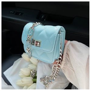 Detail of light blue quilted mini crossbody bag with silver chain and turn-lock closure