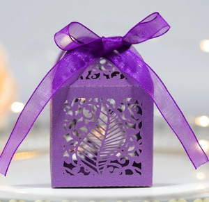 Detail of purple laser-cut leaf pattern gift box with elegant ribbon bow and pearl finish