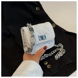 Detail of white quilted crossbody bag featuring silver chain with COCO letter charms