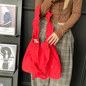 Detail of red nylon tote bag with ruffled edges and shimmering sequins for women