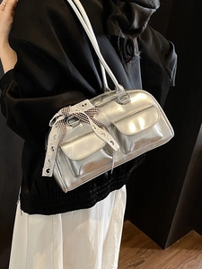 Silver metallic pillow bag with front pockets and decorative black-white checkered bow