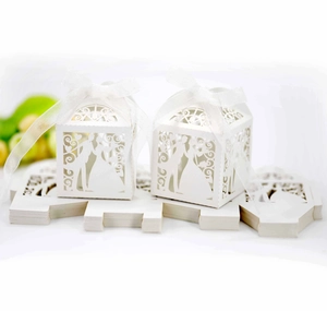 Detailed laser-cut white wedding favor boxes with elegant bride and groom silhouette designs