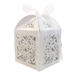 Detail of laser-cut floral pattern and white organza ribbon bow on a wedding gift box