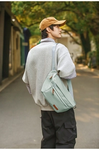 Détail d'un sac de poitrine vert clair avec bandoulière grise réglable en nylon