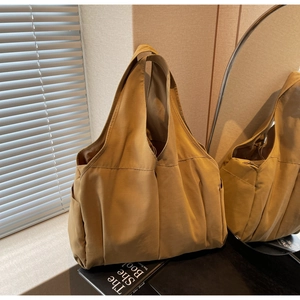 Vue macro d'un grand sac cabas en nylon jaune avec texture souple et large bandoulière