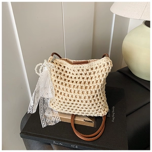 Détail du sac en crochet fait main avec bandoulière en cuir brun et nœud en dentelle