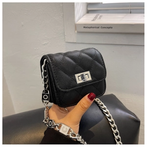 Detail of micro black quilted bag with lychee texture and silver chain strap with letters