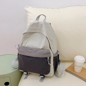 Detail view of the tricolor nylon backpack with water-resistant texture and front pocket