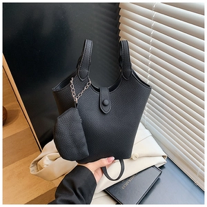 Close-up of black lychee grain leather bucket bag with a matching small coin pouch detail
