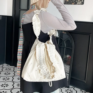 Detail shot of ivory nylon tote with wide ruffled pleated trim and soft canvas texture