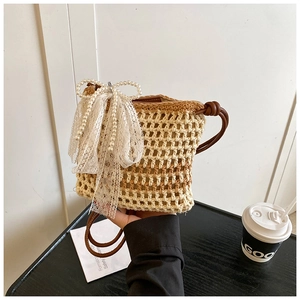 Détail du sac bandoulière tissé avec nœud en dentelle et perles pour le style d'été