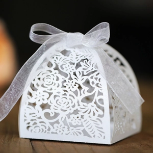 Laser cut white pearl paper wedding favor box with hollow rose pattern and ribbon bow