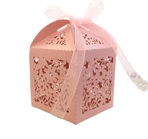 Detailed laser-cut floral pattern on pink paper favor box with organza ribbon