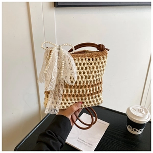 Détail d'un sac en paille tressé main avec nœud en dentelle et accents de perles