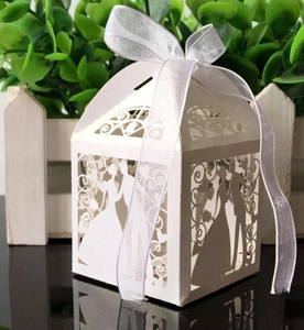 Close-up of laser-cut wedding favor box featuring bride and groom silhouette with ribbon