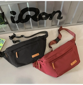 Détail de grands sacs bandoulière noir et bordeaux avec sangles réglables et logo cuir