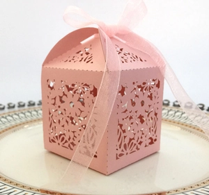 Detail of pink laser-cut flower patterns on gift box with a soft silk ribbon bow