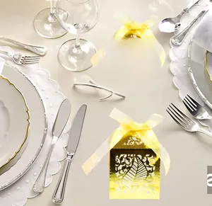 Detailed laser-cut gold leaf candy boxes with elegant ribbons for wedding table decor