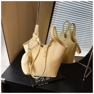Detail of yellow pebbled leather bucket bag with matching mini coin purse attachment