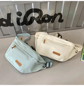 Détail de sacs bandoulière vert menthe et blanc crème avec fermetures éclair et logo