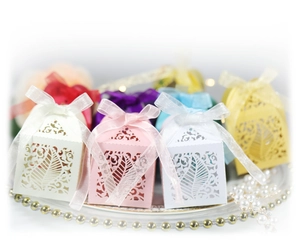 Laser cut leaf pattern candy boxes in assorted colors with elegant ribbon bows