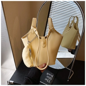 Close-up of cream yellow bucket bag featuring lychee texture and round coin purse detail