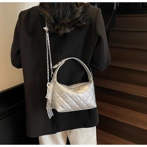 Silver quilted chain bag detail with lace and pearl charms on metal shoulder strap