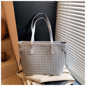Detailed view of silver woven leather tote bag with metallic hardware and luxury finish